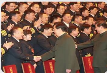 Group photo of officials in uniform shaking hands with civilians, red chairs visible (no text or symbols)